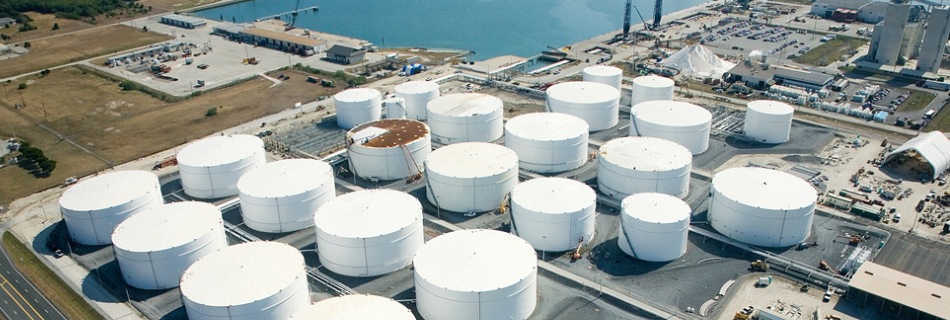 View of free-standing tanks with a sea coast in the background